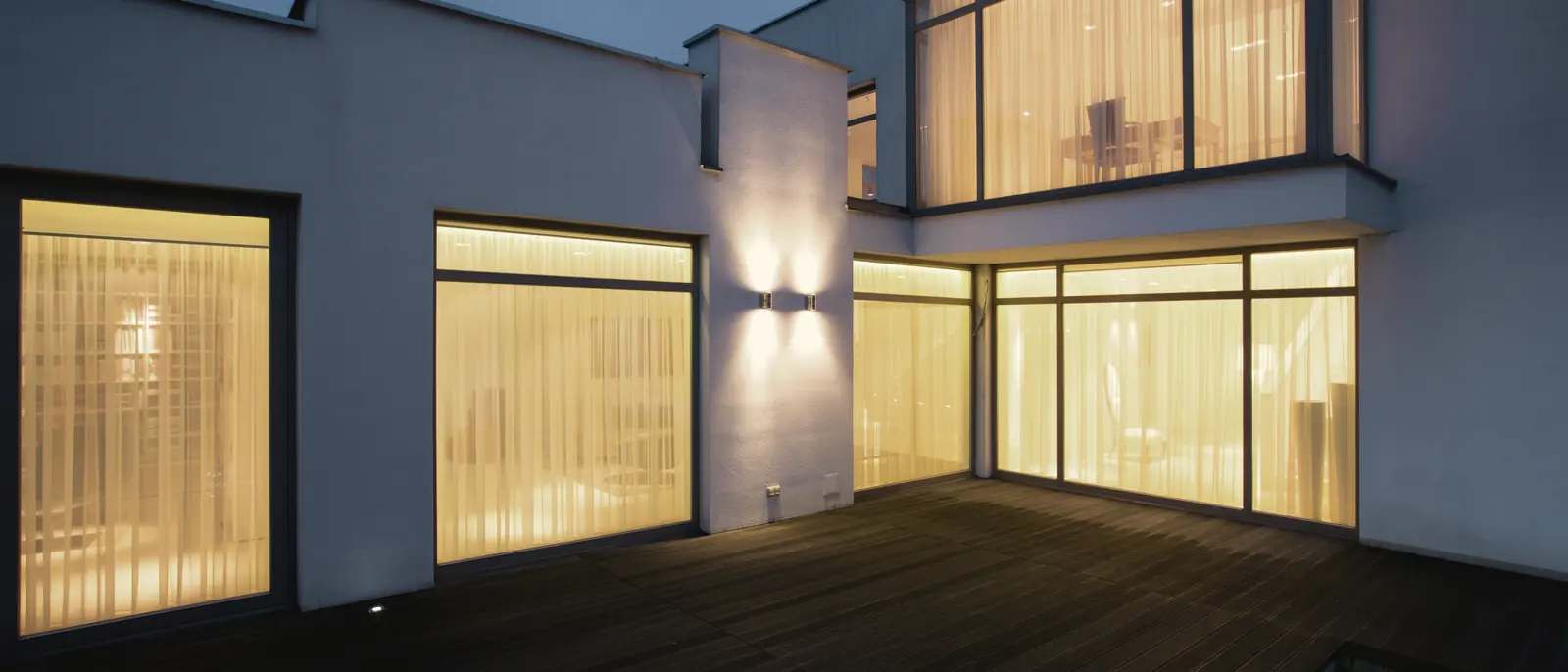 Maison moderne aux grandes fenêtres éclairées au crépuscule